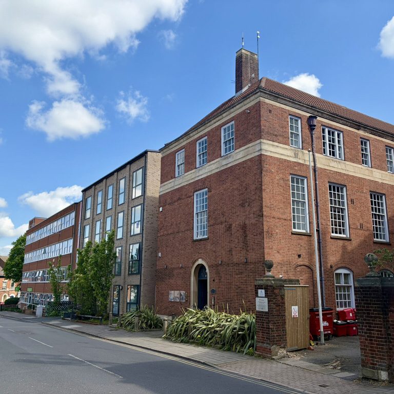 Albert Street looking north, with a three-storey red-brick building on the corner.