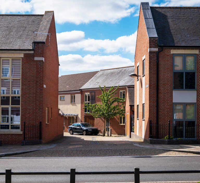 New brick townhouses arranged around a small courtyard.