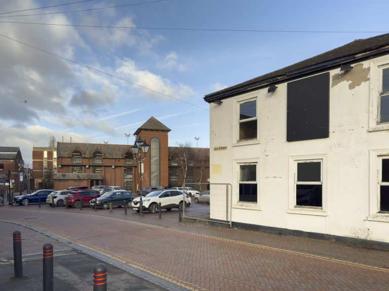 Gas Street, with a white-rendered building and the brick tower of the John Barford car park beyond.