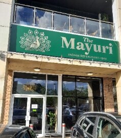 The Mayuri restaurant, with a green peacock sign above a glazed frontage.