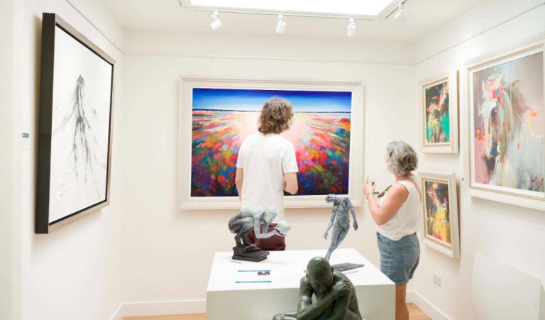 Visitors looking at paintings and sculpture inside the Lorimer gallery.