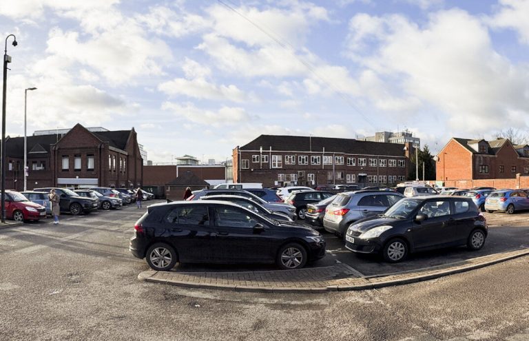 North Street car park, with parked cars and brick buildings beyond.