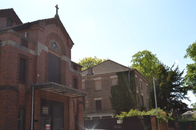 Church House and Marjorie Hume House, two empty brick buildings behind trees.