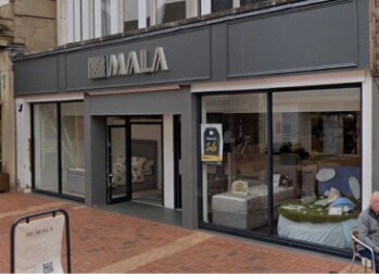 The Mala Beds shopfront after the grant, painted dark grey with large display windows.