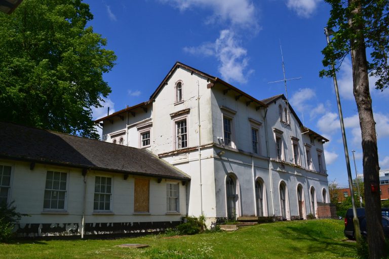 The Retreat, a white-painted two-storey listed building with arched ground-floor windows.