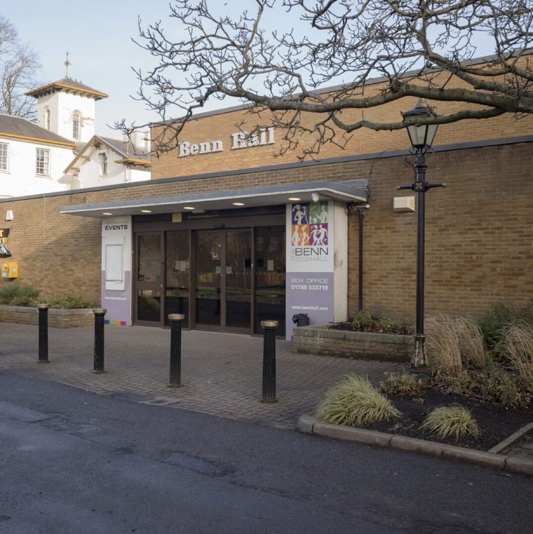 The entrance to the Benn Hall, a brick building with a glazed canopy and a lamp post.